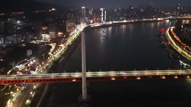Nighttime Aerial Bridge Over River City Lights