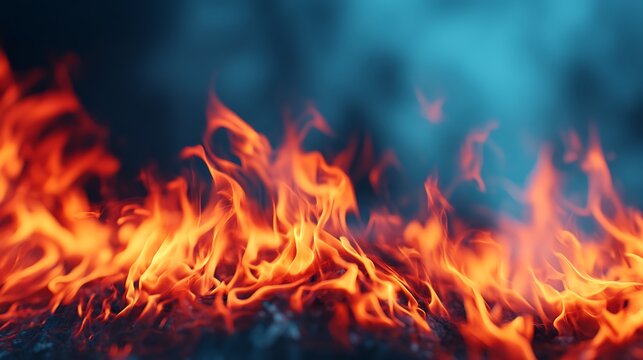 Bright orange flames dance over a dark surface, contrasting with a cool blue smoky background, creating an intense and dynamic fire scene.