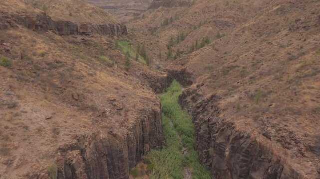 Aerial view flying through the Ayagaures Canyon near La Gambuesa Dam. This rugged landscape shows a dry riverbed and unique geology