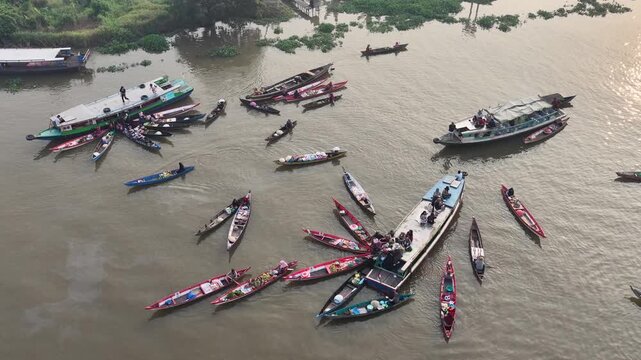 Local merchants sell goods from small boats on the river in South Kalimantan at sunrise