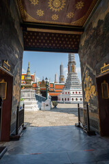 Mural doorway framing golden chedis at Wat Phra Kaew © Roberto