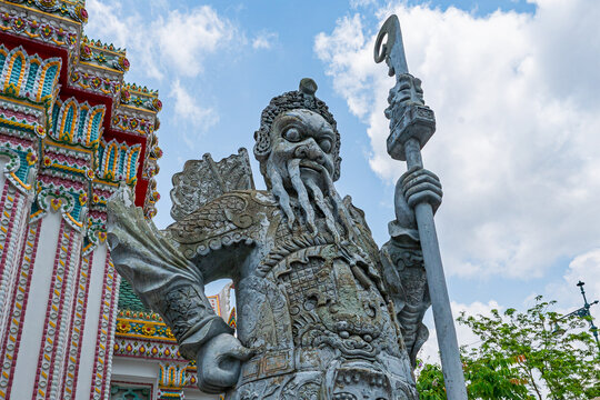 Chinese stone warrior statue with halberd at temple in Bangkok