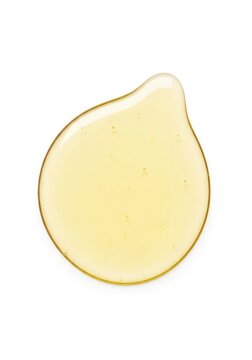 Clear liquid puddle of premium meadowfoam seed oil on a white background, highlighting the smooth texture and light golden hue of the oil, viscous, botanical, meadowfoam