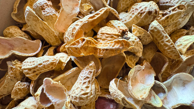 Close-up of empty roasted peanut shells, textured organic food waste background