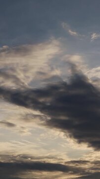 Cloudy sky at sunset. A combination of light stratocumulus and dense dark clouds. Pre-storm evening landscape with contrasting clouds. Pre-storm nature and changeable weather
