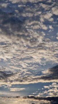 Cloudy sky at sunset. A combination of light stratocumulus and dense dark clouds. Pre-storm evening landscape with contrasting clouds. Pre-storm nature and changeable weather
