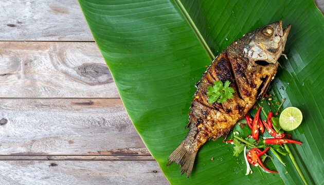 Crispy Fried Calamari Rings with Lemon Served on a Green Banana Leaf