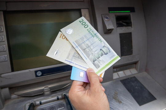 Hand holding Danish Kroner banknotes from an ATM