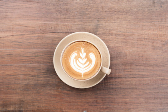 Top view closeup of cappuccino latte on brown table