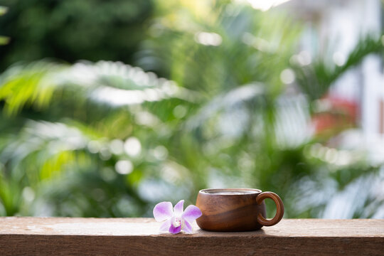Rustic wooden cup paired with a vibrant purple orchid flower
