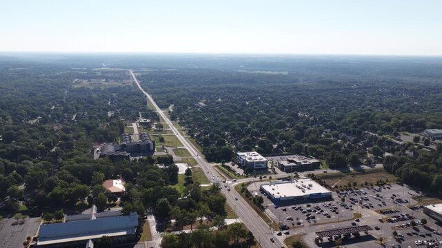Aerial of suburban commercial and residential area in Springfield Missouri with a major road running through dense forest and commercial shopping centers