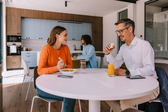 Colleagues Having Casual Breakfast Meeting in Modern Office Kitchen Over Coffee and Conversation