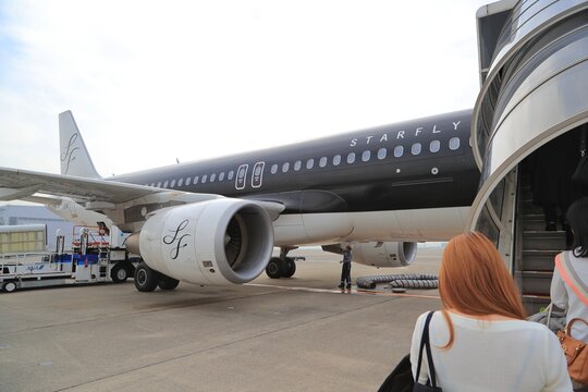 A Starflyer Airbus A320 at the boarding gate as a traveller walks toward it on November 15, 2016 in Japan.