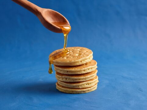Flapjack stack with honey drizzle on a blue background