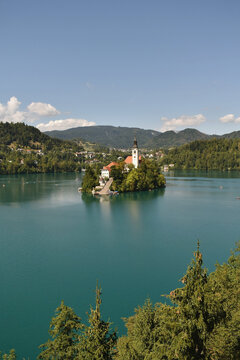 Scenic view of Lake Bled in Slovenia with island church, surrounded by mountains and calm turquoise water