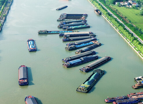 multiple cargo barges navigating busy inland waterway
