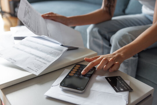 Partial woman checking financial documents at couch on sofa