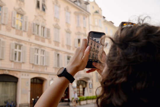 Woman photographing architecture on trip in Bolzano, South Tyrol