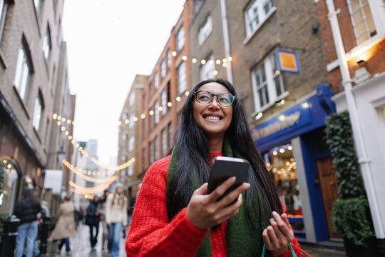 Happy woman enjoying christmas shopping in London street