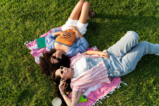 Friends Relax On Blanket In Park