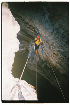 Climbing on a Rope Inside a Cave During an Exploration