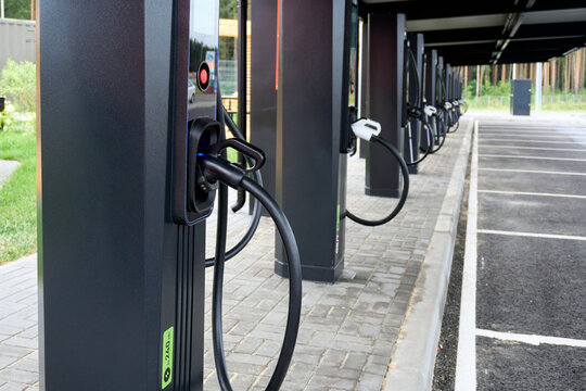 Electric vehicle charging stations lined up near a park