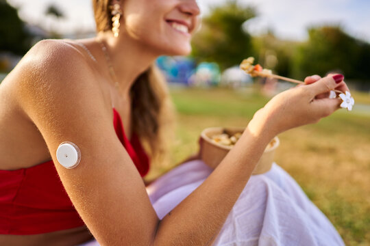 Young woman managing diabetes, enjoying a healthy picnic