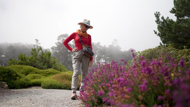 Senior woman visits Mendocino coast Botanical Gardens in Fort Bragg California, enjoying the flowers and natural beauty of the area