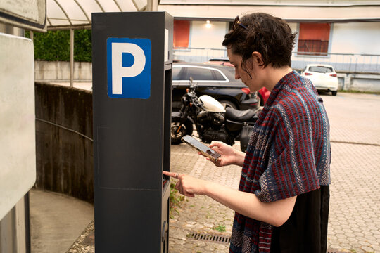 Woman Using Parking Pay Machine in a City Area