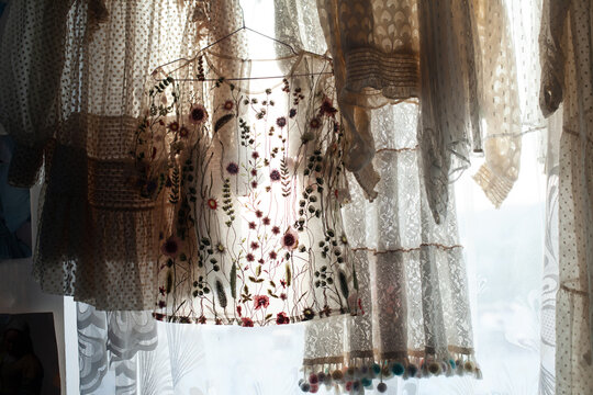 Translucent fabric and sheer dresses hanging by the window