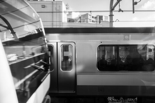 Black and White Commuter Trains Passing at Urban Railway Station