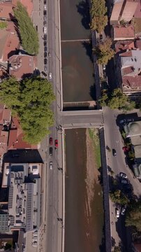 Aerial Top Down Drone View Moving Upstream Along Miljacka River and Bridges Towards Vijecnica