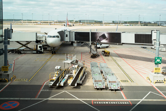 Airplane Parked at Airport Gate With Cargo Handling in View