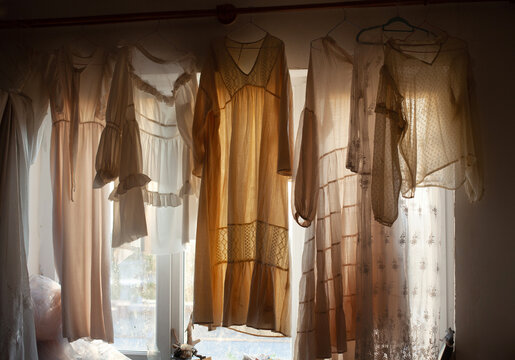 Translucent fabric and sheer dresses hanging by the window