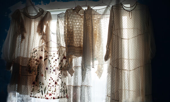 Translucent fabric and sheer dresses hanging by the window