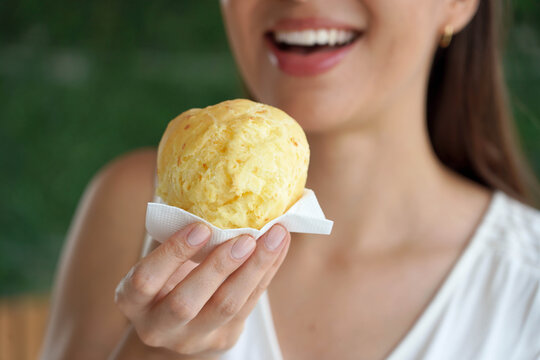 Pao de queijo (Brazilian cheese bun). Unidentified young woman showing pao de queijo Brazilian traditional recipe