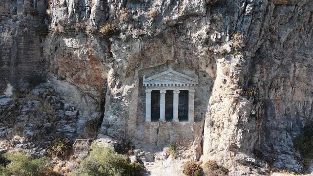 4K aerial video of the Nişanyan Rock Tomb in Şirince, Turkey, showcasing the ancient rock-cut burial site and its surrounding natural landscape.