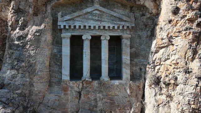 4K aerial video of the Nişanyan Rock Tomb in Şirince, Turkey, showcasing the ancient rock-cut burial site and its surrounding natural landscape.