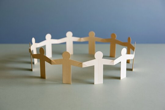 Ring of linked paper people standing on a smooth sage green surface, representing unity and mutual support for community campaigns