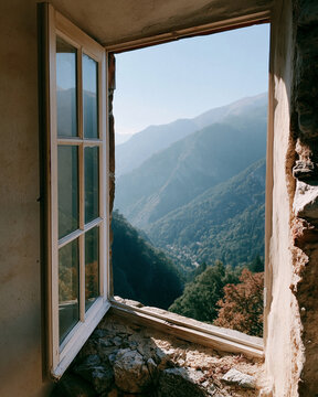 Sunlight streams through a rustic, open window. Mossy stone walls frame the view. Distant mountains rise beneath a clear blue sky. Lush green valleys stretch below, filled with trees