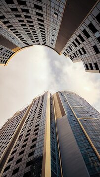 Low angle view of modern glass skyscrapers reaching towards the sky.