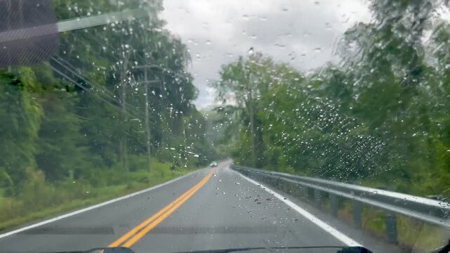driving on stormy country road with oncoming traffic 