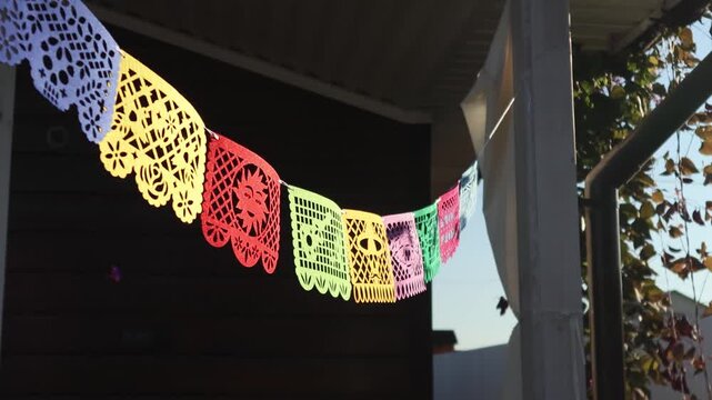 Dia de los Muertos outdoor papel picado banners hung along a sunny patio