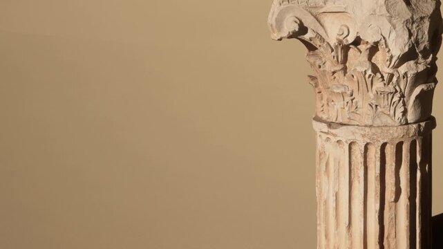 A close view of an ancient column with intricate designs. The column stands in a museum, showcasing historical craftsmanship. Light highlights the details on the stone.
