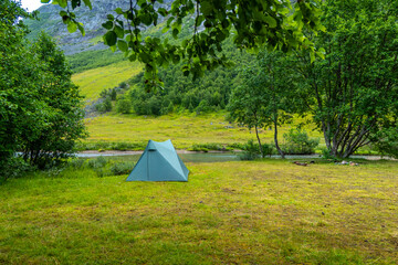 A beautiful green summer landscape with a tent near a river. A summer scenery of World Heritage Area in Western Norway. © dachux21