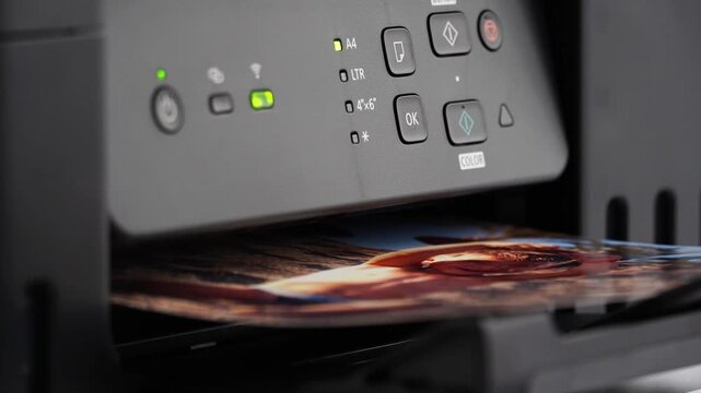 Printer ejects vivid video with smooth motion. Control panel glows with operational indicators. Paper emerges with crisp, colorful output. Perfect for tech, design, or home office visuals. No people