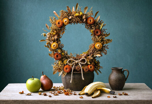 Autumnal floral wreath arrangement with seasonal fruits and rustic ceramic pitcher on neutral table setting