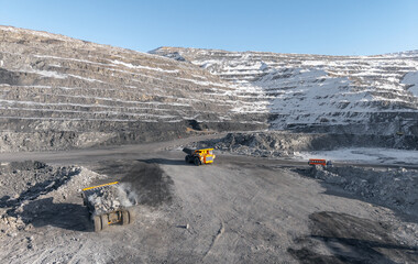 Vast open pit coal mine in winter landscape with dump trucks © Parilov