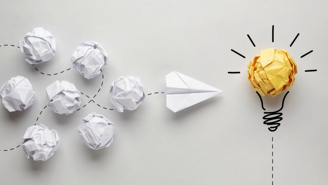 Creative process with crumpled paper balls and a paper plane forming a light bulb