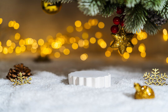 Christmas Holiday background with snow, fir tree and decorations with christmas light behind. Christmas podium for product demonstration on a winter festive background.